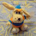 peluche d'un chien habillé en orange et bleu